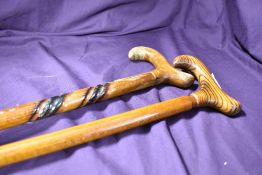 Two wooden walking sticks one with a decorative twist to the shaft