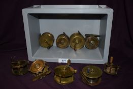 9 small vintage brass fishing reels measuring from 1.75 inch diameter to 2.5 inch diameter