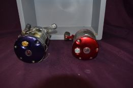 Two Abu Garcia Ambassadeur multiplier reels a red 5000 and a blue 7000 C4LD both in used condition