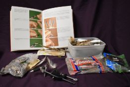 A small selection of fly tying equipment including vice, feathers and a book on flytying techniques