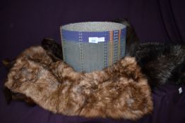 A round hat box containing 3 animal stoles including mink and fox