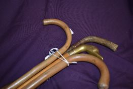 Four walking canes all approximately 92cm long one having a brass goose or ducks head handle