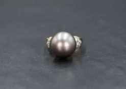 An 18ct gold pearl and diamond set ring, the central purple-grey possibly Tahitian pearl having five
