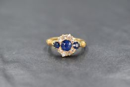 An Edwardian 18ct gold sapphire and diamond ring having a central sapphire, approx 0.5ct flanked
