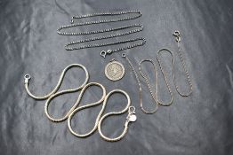 A group of three silver chains comprising a curb link, a herringbone link and a snake link chain,