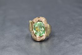 A 14ct gold paste and diamond set ring, the contemporary ring having a central oval cut green