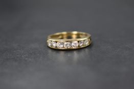 A 9ct gold cubic zirconia set band, the seven round brilliant cut cubic zirconia in a channel