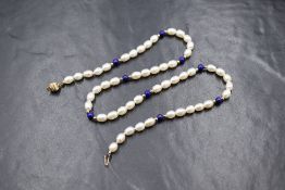 A pearl and lapis lazuli necklace, the row of rice pearls having a white-pink lustre interspersed