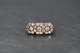 An 18ct gold diamond set ring, the three interlocking floral motifs set with old cut diamonds, total