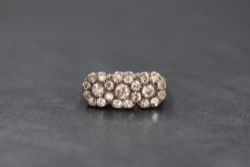 An 18ct gold diamond set ring, the three interlocking floral motifs set with old cut diamonds, total