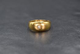 A Victorian 22ct gold band ring having a small inset old cut diamond in a star burst setting, size M