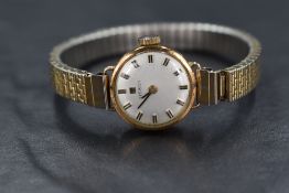 A lady's 9ct gold wrist watch by Tissot having a baton numeral dial to circular face in a plain gold