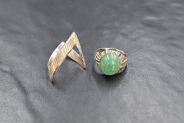 A small silver ring having an oval aventurine cabochon stone in a bezel mount to bark effect