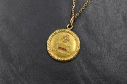 A yellow metal presumed gold French 'medaille amour' pendant, of circular form having a laurel