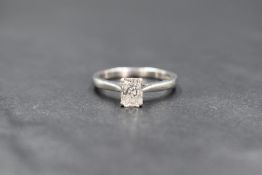 A platinum diamond solitaire ring having a 0.70ct rectangular brilliant cut diamond in a four claw