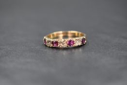 A 9ct gold half eternity ring having four small rubies interspersed by three diamond chips in a pave