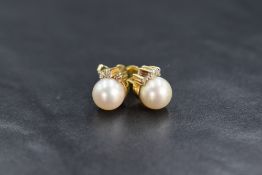 A pair of yellow metal presumed gold pearl and diamond set stud earrings, the cultured pearls having