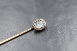A Victorian yellow metal stick pin having a moonstone cabochon and old cut diamond chip cluster