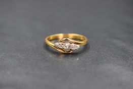 A yellow metal five stone diamond ring stamped 18ct having five small graduated old cut diamonds