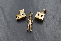 A group of three 9ct gold charms, comprising a policeman with an articulated head, and two