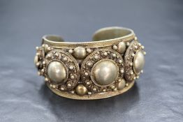 A white metal cuff bangle stamped Siam Sterling having traditional applique decoration, approx 66.