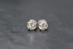 A pair of 18ct white gold diamond solitaire stud earrings, the round brilliant cut diamonds
