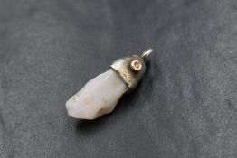 A white metal presumed silver mounted raw opal pendant, the raw opal having an organic moulded mount