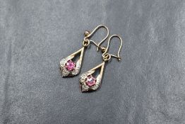 A pair of yellow metal, presumed 9ct gold loop drop earrings having pink tourmaline and diamond chip