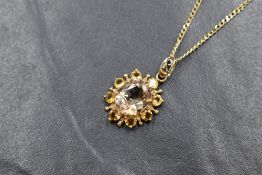 A 9ct gold champagne topaz and citrine open cluster pendant on an 18' 9ct gold curb link chain,