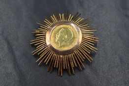 A gold half sovereign dated 1912 in a large yellow metal removable brooch/pendant mount, approx 15.