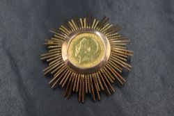 A gold half sovereign dated 1912 in a large yellow metal removable brooch/pendant mount, approx 15.