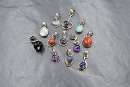 Twelve white metal polished stone pendants, most stamped 925, including lapis lazuli, agate,