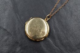 A 9ct gold circular locket of plain form on an 18' 9ct rose gold chain having barrel clasp, approx