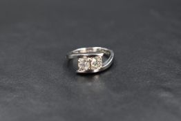 An 18ct white gold diamond set cross over ring, the two old cut diamonds measuring approximately 0.