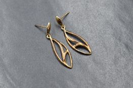 A pair of 9ct gold drop earrings, having pierced oval motif drops on post backs, lacking butterfly