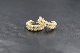 A pair of yellow metal pearl set hoop earrings, the two rows of cultured pearls on an openwork