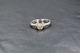 An 18ct white gold diamond set solitaire ring, the central round brilliant cut diamond in a bezel