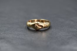 A 9ct gold band, having two clasped hands to the centre , marked 375, ring size M-N, 3.1g