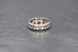 An 18ct white gold wedding band having bright cut decoration, size J & 3.4g