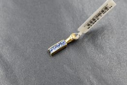 A small 18ct gold mounted ceylon sapphire pendant having four small princess cut stones in a channel