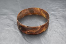 A Victorian tortoise shell bangle having yellow metal pin fasteners, inner diameter approx 68mm