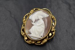 A yellow metal cameo set brooch, the large cameo depicting Hebe goddess of youth or of the prime