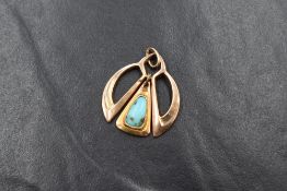 A 9ct rose gold Art Nouveau pendant having a bezel set turquoise in a central swing mount, approx