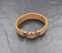 A Victorian yellow metal and hairwork mourning bracelet, the plaited band having a yellow metal