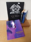 A selection of Queen books and some drumsticks - a nice set of collectables