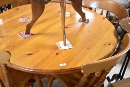 A modern pine kitchen dining table of circular form and a set of four complimentary rubber wood