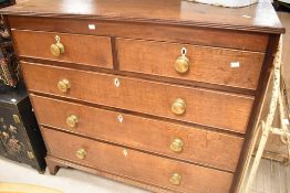 A 19th century oak chest of two over three drawers having brass handles, bone escutcheons and