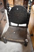 An Antique Low/Pidha chair, probably from the Indian subcontinent region, having carved back and