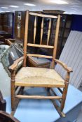 A 19th Century rush seated rocking chair having turned rail back