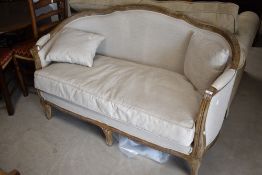 A vintage settee in the French style having limed effect frame and neutral upholstery, width approx.